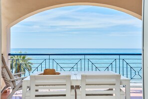 A balcony with a view of the sea, white furniture, and a palm tree. - Apartment 'Blue View' with Sea View, Wi-Fi and Air Conditioning (Torrox Costa)