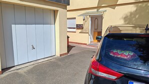 Garatge residencial amb una porta blanca, un cotxe estacionat i una petita tenda sobre la porta del garatge.