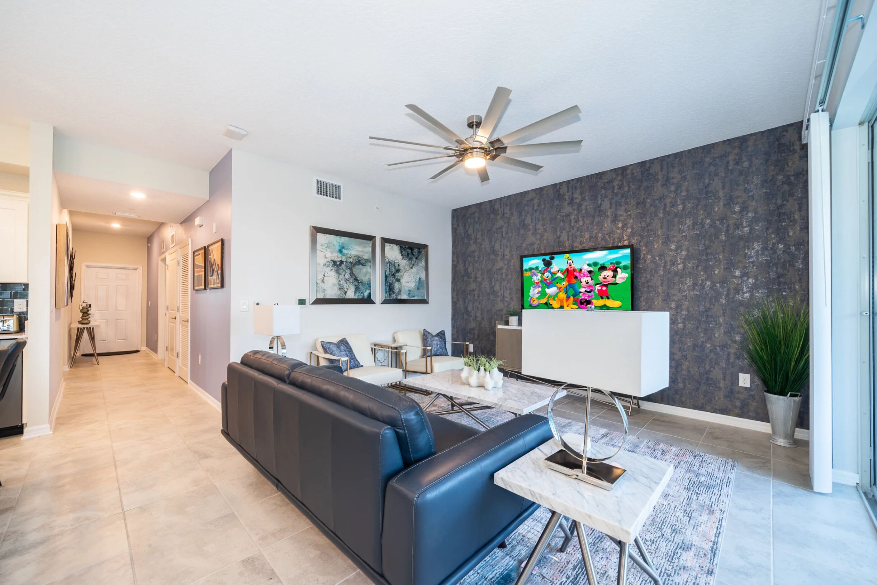 A modern living room with a sofa, a coffee table, and a TV.