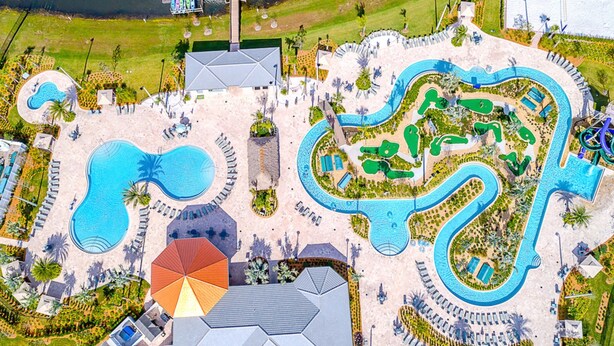 Ett flygbildsfoto av ett semesterområde med flera pooler, en stor central pool och olika typer av vackert anlagda områden.