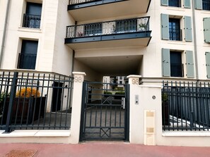 Um edifício com vários andares, varandas, portão e placa com o número 93.