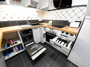 A compact kitchen with a dishwasher, oven, and a built-in microwave. - Melody Clamart, 25 min from Paris, Tramway 6, Parking (Clamart)