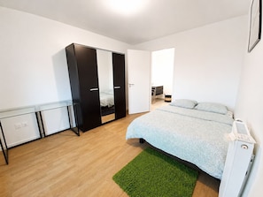 A bedroom with a bed, a wardrobe, a desk, and a radiator. - Melody Clamart, 25 min from Paris, Tramway 6, Parking (Clamart)