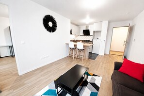 Um apartamento moderno com sala de jantar, cozinha e sala de estar.