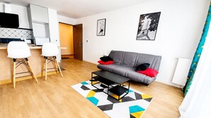 A modern living room with a grey sofa, a coffee table, and a geometric rug. - Melody Clamart, 25 min from Paris, Tramway 6, Parking (Clamart)