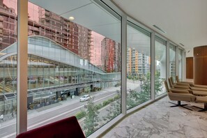 A hotel lobby with large windows, a curved glass facade, and a view of a city street. - Unique one bedroom Yaletown Vancouver apartment (Vancouver)