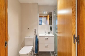 Ein kleines Badezimmer mit Toilette, Waschbecken und Stauraumschrank.