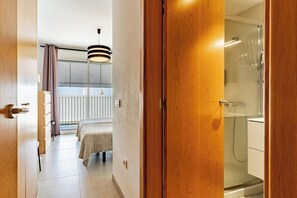 A hotel room with a bed, a shower, and a balcony with a hanging light fixture. - Premium Penthouse · Private Terrace · Ocean View (Adeje)