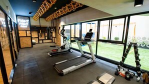 Une salle de sport équipée de tapis de course, d’un vélo d’appartement et d’un rameur.