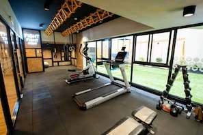Ein Fitnessraum mit Laufbändern, einem Ergometer und einem Rudergerät.