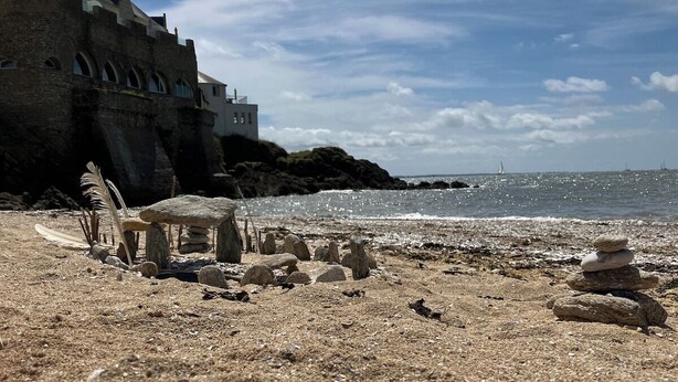 A beach with a stone structure, a building with arched windows, and a clear sky. - Superb house 85m² - Beaches 2km away - Enclosed garden (Billiers)