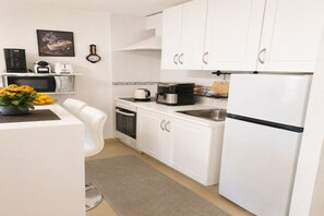 A compact kitchen with white cabinets, a microwave, a coffee maker, and a refrigerator. - Cozy apartment on the sea shore (Costa de la Calma)