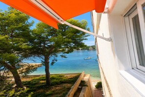 A balcony with an orange awning overlooking a body of water with boats. - Cozy apartment on the sea shore (Costa de la Calma)