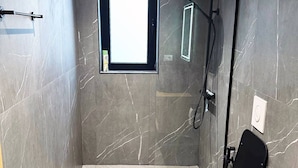 Ein modernes Badezimmer mit Toilette, Dusche und kleinem Fenster.
