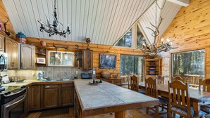 L’intérieur d’une cabane comprend une cuisine, un coin repas et de grandes fenêtres.