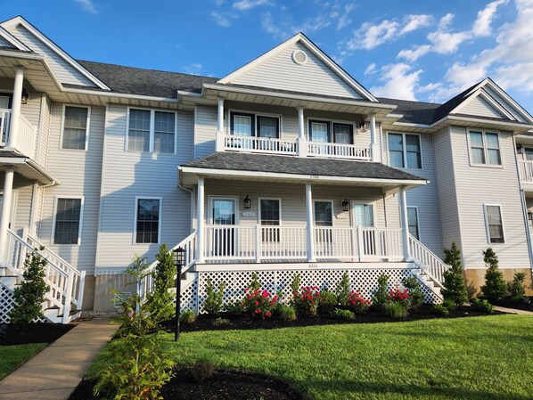 A two-story residential building with a front porch, a covered entryway, and a small garden with red flowers. - Spacious 3 Bedroom 2 Full baths in Wildwood Crest. 3 Blocks from to the beach. (Wildwood)