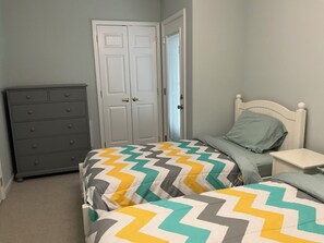 A bedroom with two beds, a dresser, and a door. - Spacious 3 Bedroom 2 Full baths in Wildwood Crest. 3 Blocks from to the beach. (Wildwood)