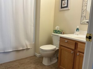 A bathroom with a toilet, a sink, a cabinet, a towel, and a shower curtain. - Spacious 3 Bedroom 2 Full baths in Wildwood Crest. 3 Blocks from to the beach. (Wildwood)