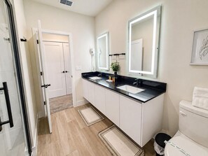 Un baño moderno con lavamanos doble, inodoro y zona de ducha.