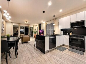 A modern kitchen with a central island, built-in oven, and microwave. - 4BR Private Pool Home with Lake View Near Disney | Sleeps 10 (Clermont)