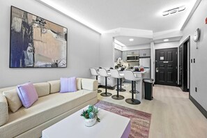 Ein modernes Wohnzimmer mit einer Couch, einem Couchtisch und einem Gemälde an der Wand.