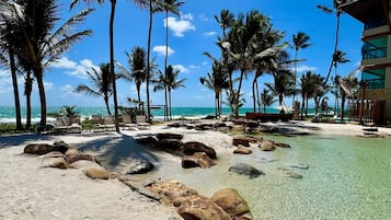 On the beach, white sand, sun loungers, beach umbrellas