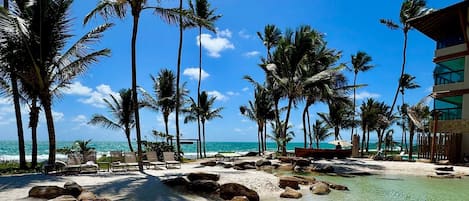 On the beach, white sand, sun loungers, beach umbrellas