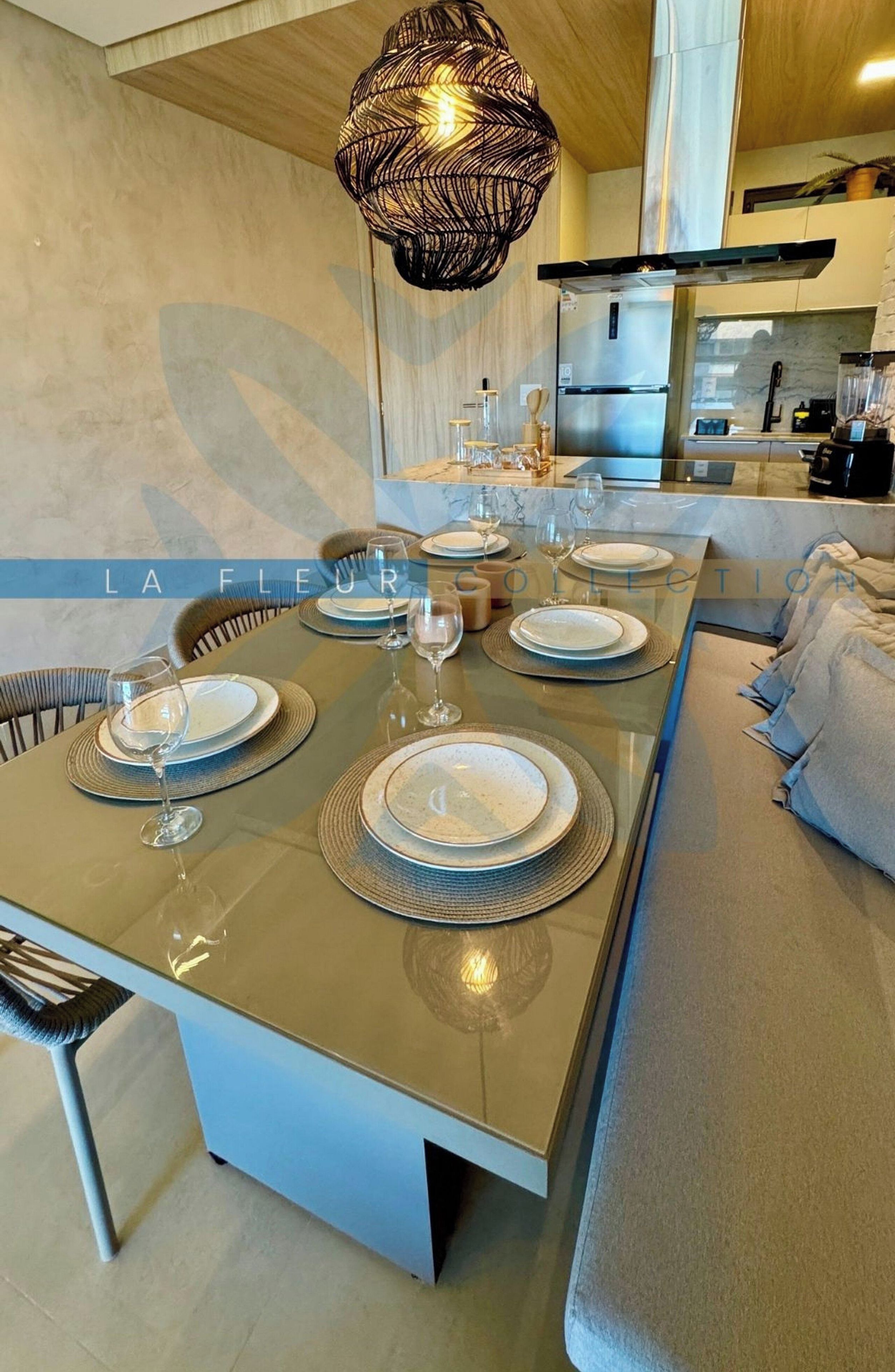 Una cocina moderna con una isla central, electrodomésticos de acero inoxidable y un colgador de luces.
