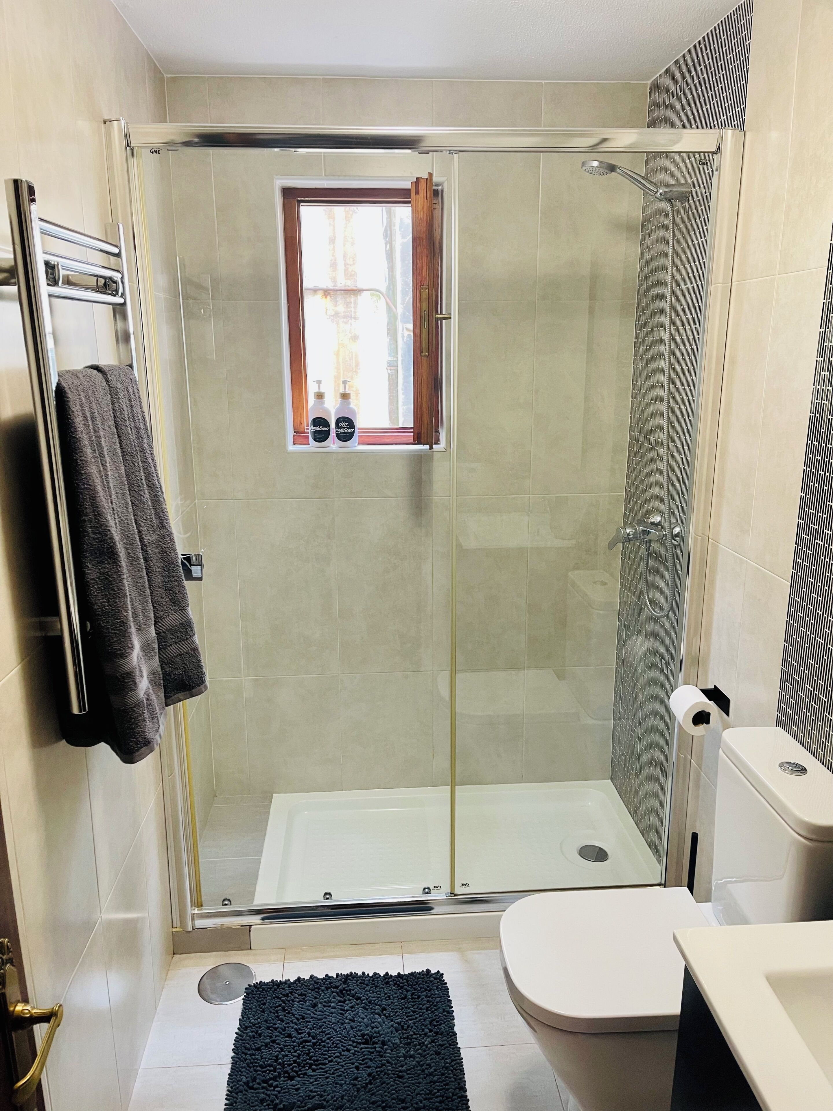 Ein Badezimmer mit Duschkabine, Toilette und Waschbecken.