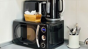 A kitchen with a microwave, coffee maker, and utensils. - Apartment San francisco Oviedo (Oviedo)