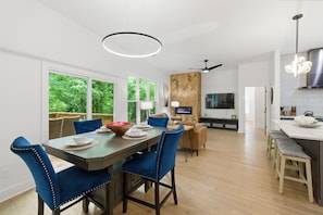 A modern kitchen with a dining area, large windows, and a herringbone-patterned wall. - Rooftop Skyline Retreat w. Beltline Access (Atlanta)