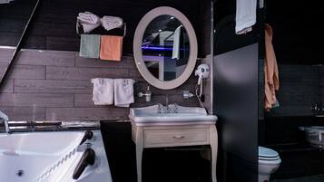 Une salle de bain moderne avec un lavabo blanc, un miroir rond et un mur en bois foncé.