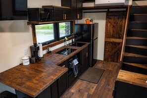 A compact kitchen with a microwave, coffee maker, and a sink. - Cozy 1-bedroom cabin in soothing Island Park next to Hank the painted stallion (Island Park)