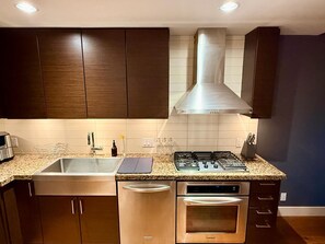 A modern kitchen with stainless steel appliances, a built-in oven, and a range hood. - Resort-Style Condo In a Prestigious Golf Community (Victoria)