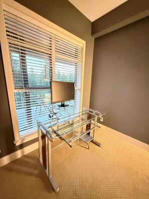 A room with a large window, a TV, and a metal shelf unit. - Resort-Style Condo In a Prestigious Golf Community (Victoria)