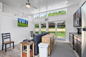 Una cocina moderna con comedor, ventanas amplias y vistas al exterior.