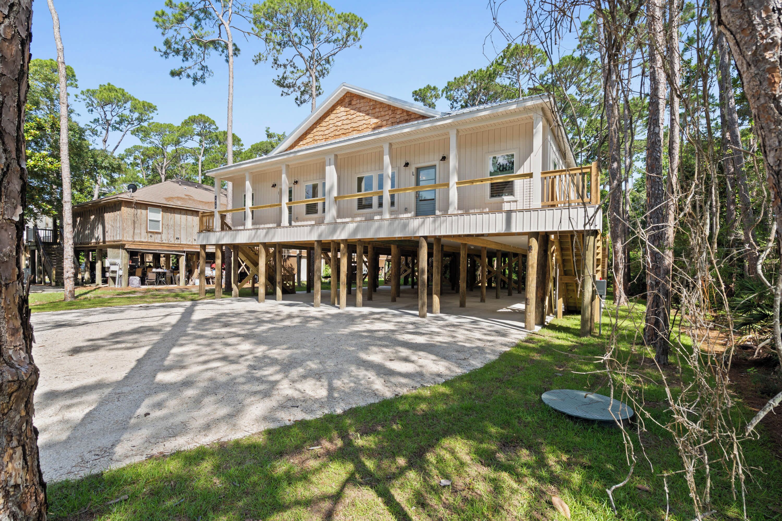 Un bâtiment à deux étages doté d’une terrasse en bois et d’un espace extérieur abrité.