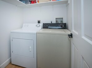 A laundry room with a front-loading washer and a top-loading dryer. - Sun Vail 32b, 2BD Condo With Vail Mountain Views (Vail)