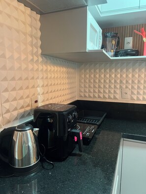 A kitchen with a coffee maker, a kettle, and a toaster. - Apartamento completo, próximo ao aeroporto de Guarulhos - Via alameda (Guarulhos)