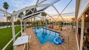 Una piscina exterior techada con sillas de descanso y un área de barbacoa.