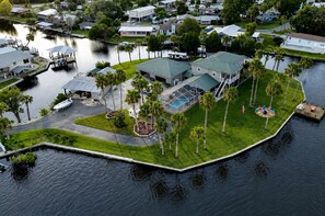 Una zona residencial con un muelle, piscina y un bote.