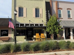 A building with a storefront named 'Ballard Financial Group' and a Village Barber Shop across the street. - Spacious 3-bedroom apartment in the heart of charming Historic Clermont (Clermont)