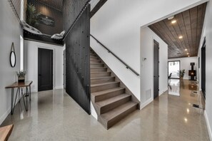 Ein modernes Interieur mit Treppe, Essbereich und Wohnzimmer mit Kamin.