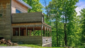 Eine Holzhütte mit Veranda, umgeben von Bäumen.