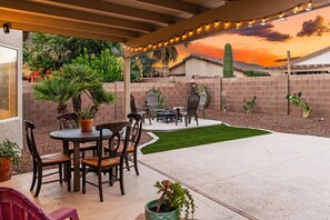 An outdoor patio with a table and chairs, a fire pit, and cacti. - Secluded Retreat: Private, Beautiful Home Wow (Tucson)