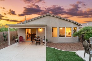 A single-story house with a patio, a dining area, and a bedroom visible through a window. - Secluded Retreat: Private, Beautiful Home Wow (Tucson)