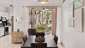 A modern kitchen with a dining area, a ceiling fan, and a view through a glass door. - Peaceful Waterfalls Luxury 2BR (FC872) (Humacao)