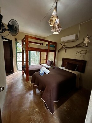 Una camera da letto con un letto a castello, un comodino, una lampada a sospensione e una finestra vista.