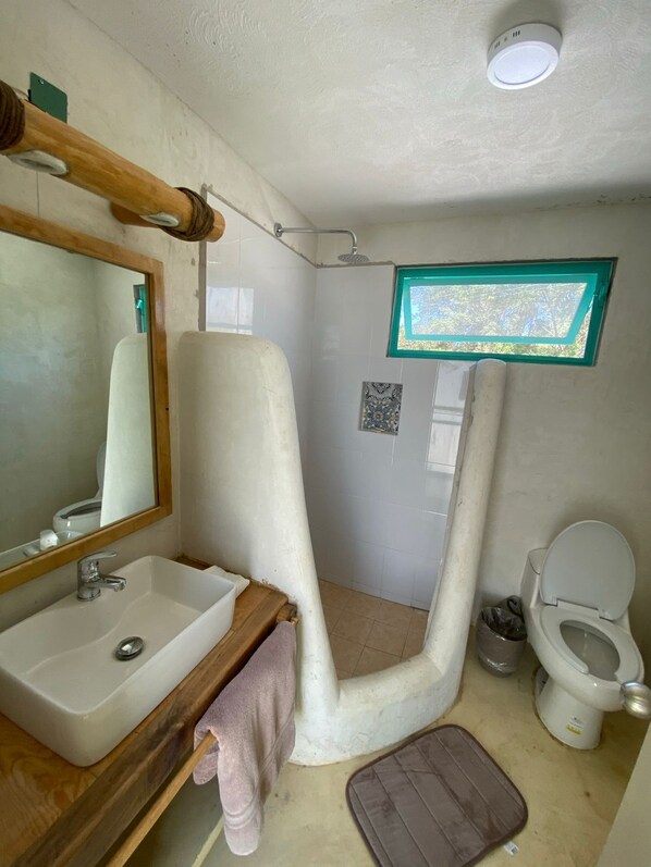 A bathroom with a sink, mirror, toilet, shower, and a window with a view. - Casa Tropical Nibasan, beautiful garden and swimming pool (San Francisco)