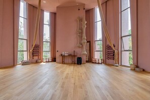 A spacious room with large windows, a wooden floor, and a central table with a speaker. - 1BR Penthouse in Aflora condo w/ Private Pool (Tulum)